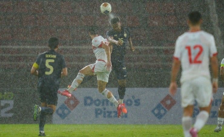 Pha tranh chấp bóng bổng của cầu thủ U23 Thái Lan và U23 Lebanon dưới trời mưa.