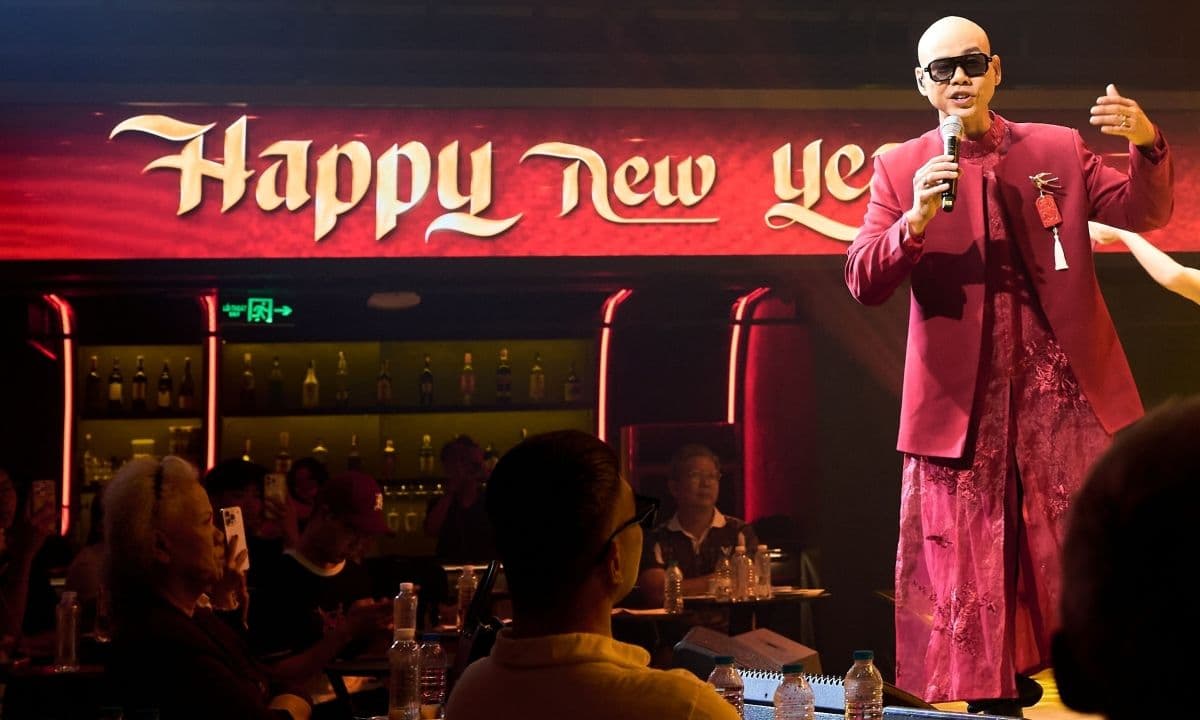 Phan Đinh Tùng biểu diễn ca khúc 'Happy New Year' trên sân khấu rực rỡ sắc đỏ.