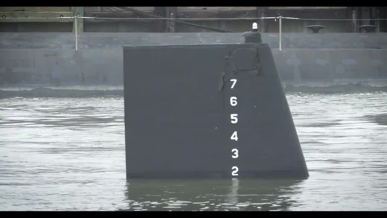 Phần thân tàu ngầm USS Boise nổi trên mặt nước, tượng trưng cho việc ngừng hoạt động và chi phí bảo trì.