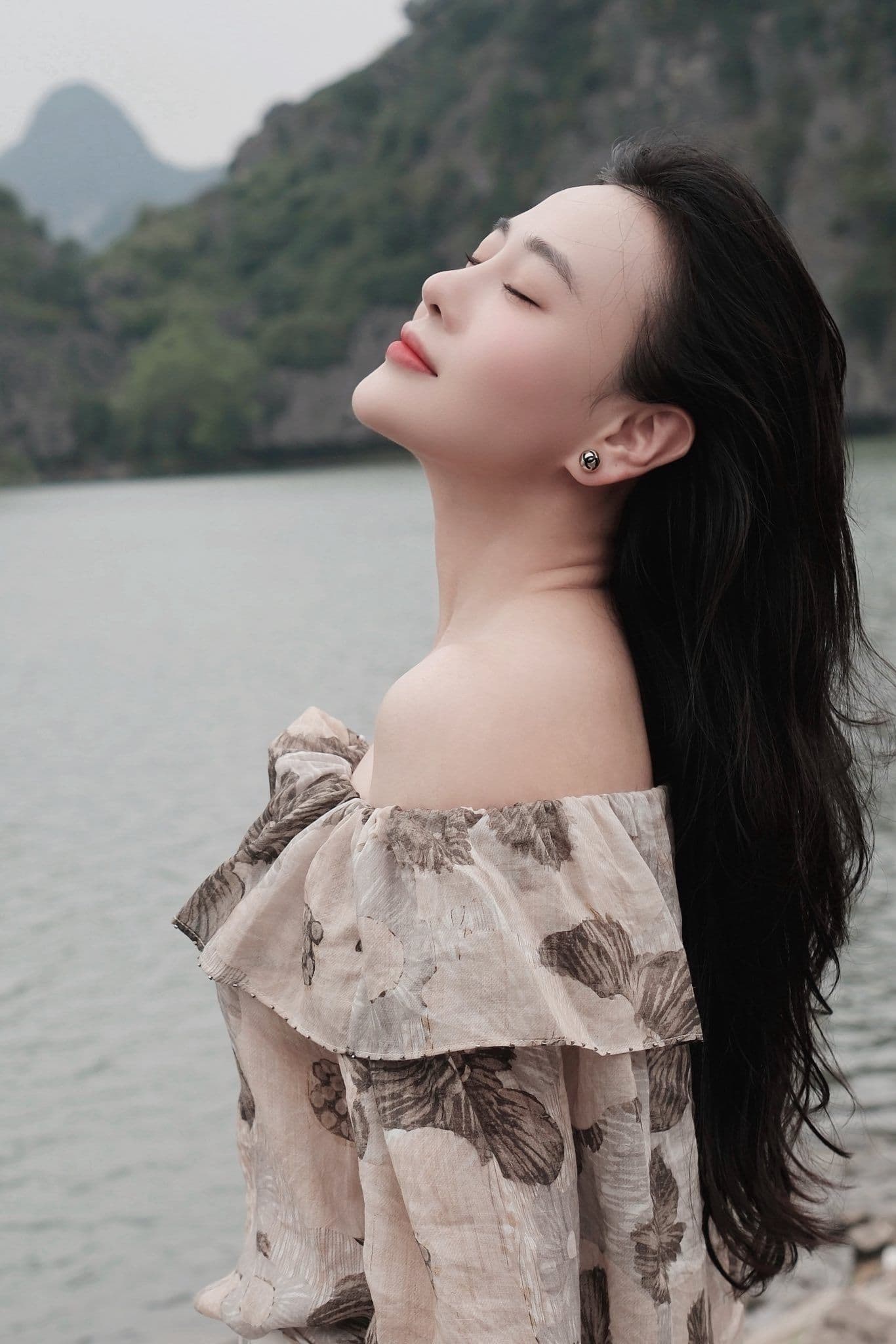 Phương Oanh nhắm mắt thư thái, tận hưởng khoảnh khắc bình yên giữa thiên nhiên, tượng trưng cho sức mạnh nội tại và bản lĩnh.