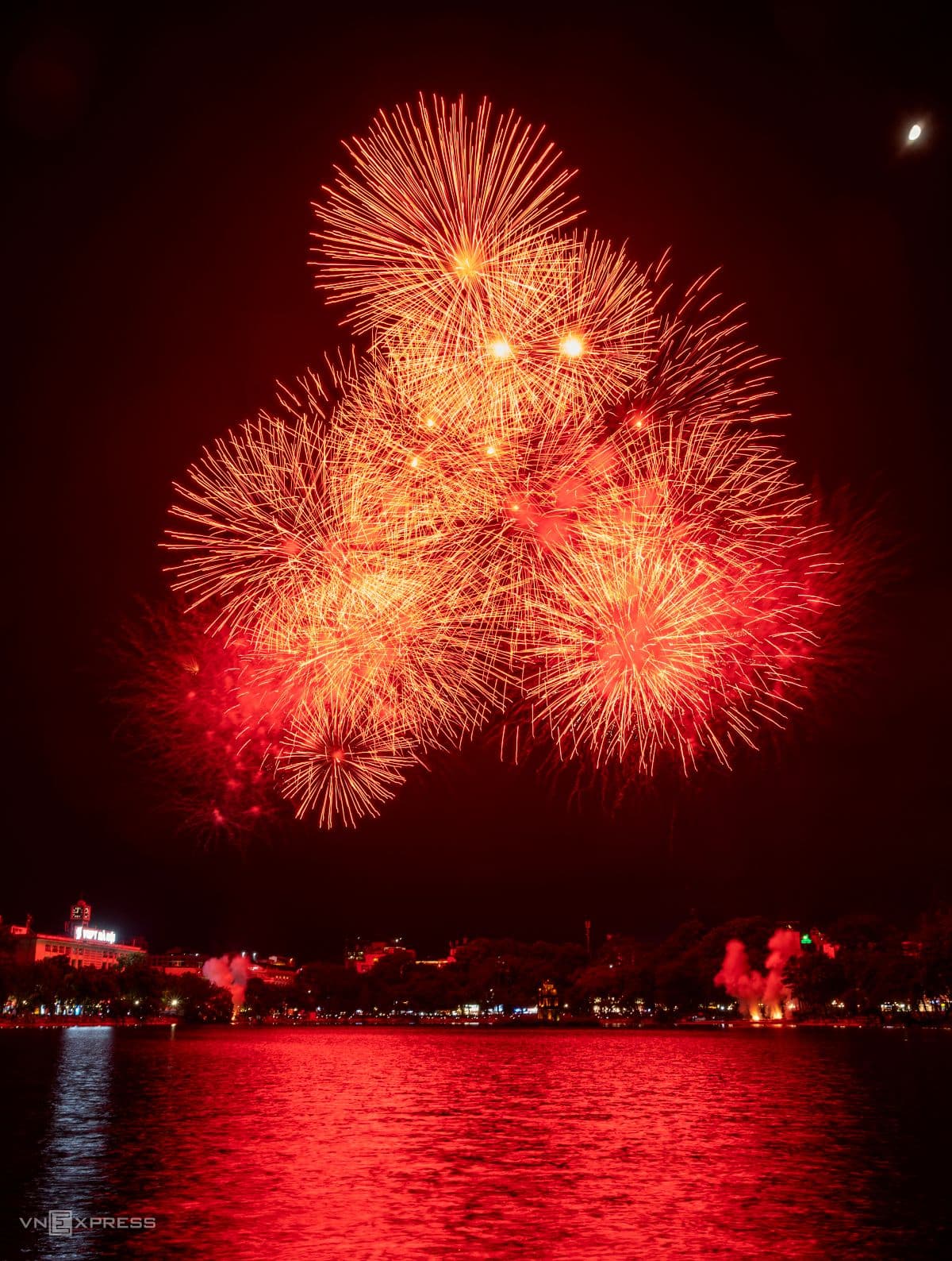 Pháo hoa đỏ rực rỡ trên bầu trời Hồ Gươm, Hà Nội, trong đêm Quốc khánh trang nghiêm.