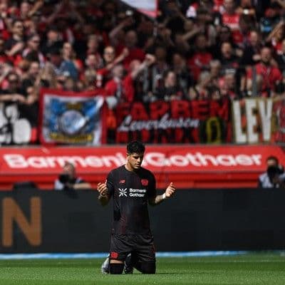 Piero Hincapié quỳ gối trên sân cỏ, thể hiện sự tập trung hoặc khoảnh khắc cá nhân trong sự nghiệp bóng đá của anh.