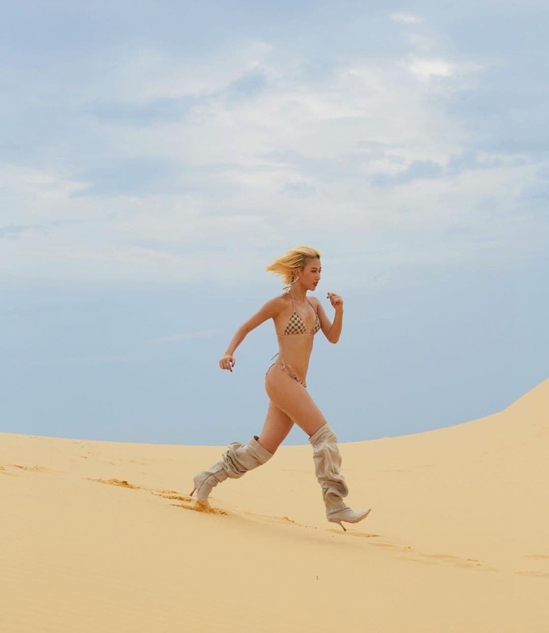 Quỳnh Anh Shyn trong bộ bikini và boots trên đồi cát, một trong những bộ ảnh thời trang táo bạo từng gây tranh cãi.