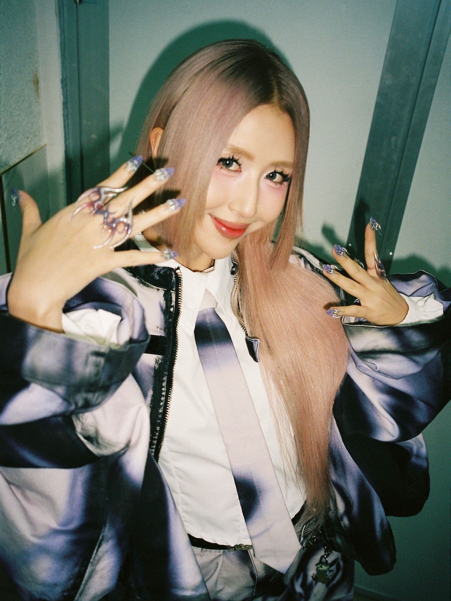 Quỳnh Anh Shyn với mái tóc hồng và phong cách thời trang độc đáo, thể hiện con đường sáng tạo đầy thị phi của cô.