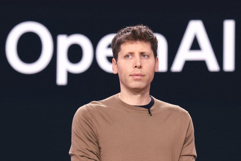 Sam Altman, CEO OpenAI, phát biểu tại hội nghị, với logo OpenAI phía sau.