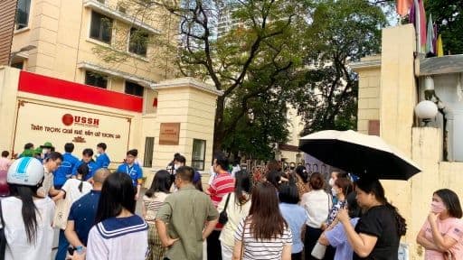 Sinh viên và phụ huynh tập trung trước cổng trường đại học, tượng trưng cho môi trường giáo dục y khoa.