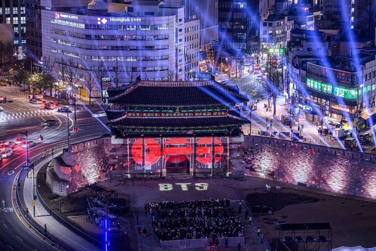 Sân khấu BTS tại Quảng trường Gwanghwamun, Seoul với đám đông người hâm mộ và ánh đèn rực rỡ