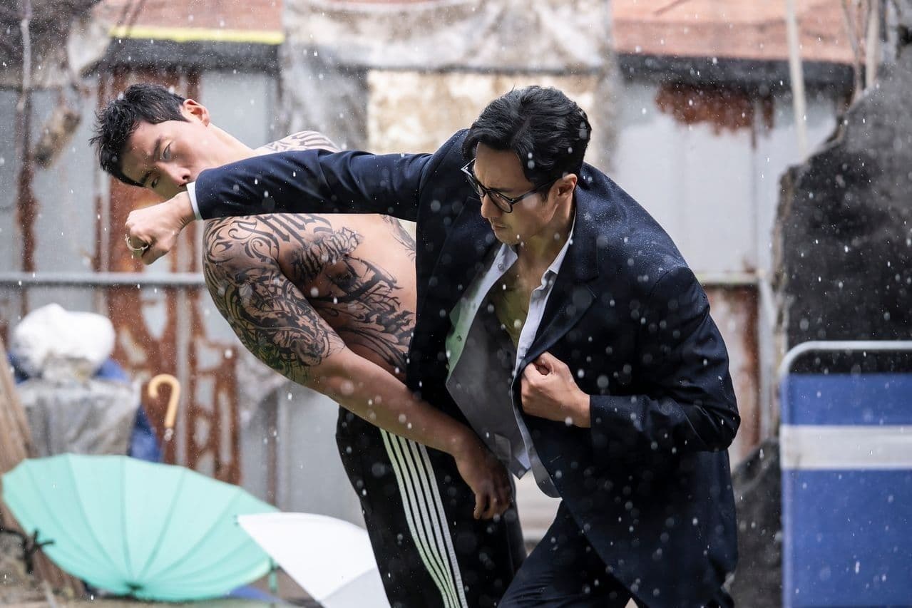 So Ji Sub trong vai Đặc vụ Kim chiến đấu dưới mưa, thể hiện sự quyết liệt phản đòn trong phim 'Đặc vụ Kim tái khởi động'.