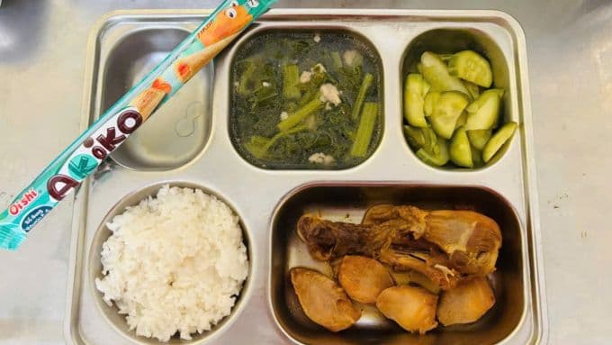 Suất ăn bán trú của học sinh trên khay, đại diện cho bữa cơm học đường bị nghi ngờ về an toàn thực phẩm.