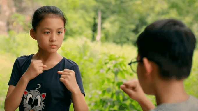 Tú (Ali Thục Phương) với nét bướng bỉnh, mạnh mẽ trong một cảnh phim 'Cách em 1 milimet', đại diện cho tinh thần tuổi thơ không internet.