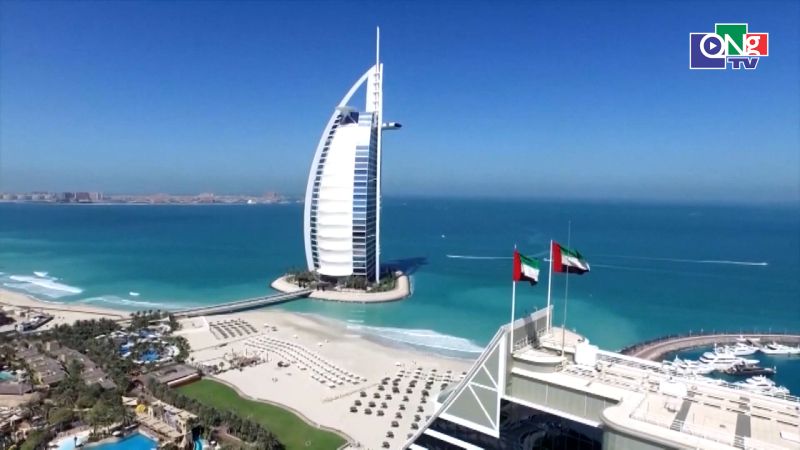 Tòa nhà hiện đại và bãi biển Dubai, tượng trưng cho sự phát triển toàn cầu và tương lai của tài sản số trong giao dịch tài chính.