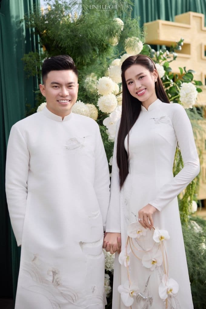 Đỗ Thị Hà và chú rể Nguyễn Viết Vương trong lễ ăn hỏi, diện áo dài trắng với họa tiết chim Lạc, thể hiện tình yêu và văn hóa truyền thống.