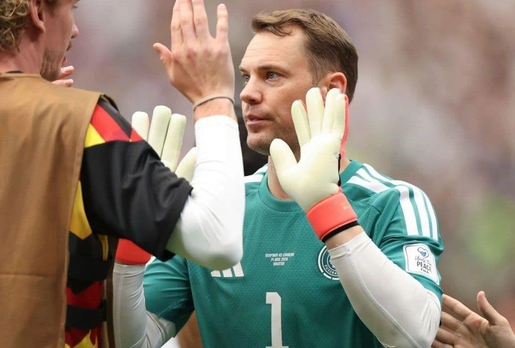 Thủ môn Manuel Neuer của đội tuyển Đức trao đổi với đồng đội, tượng trưng cho sự trở lại và thông điệp tích cực từ truyền thông.