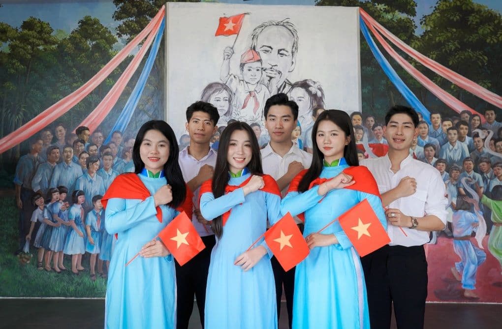 Thanh niên Việt Nam trong trang phục truyền thống, cầm cờ Tổ quốc, thể hiện tinh thần giáo dục mới và khát vọng dân tộc.