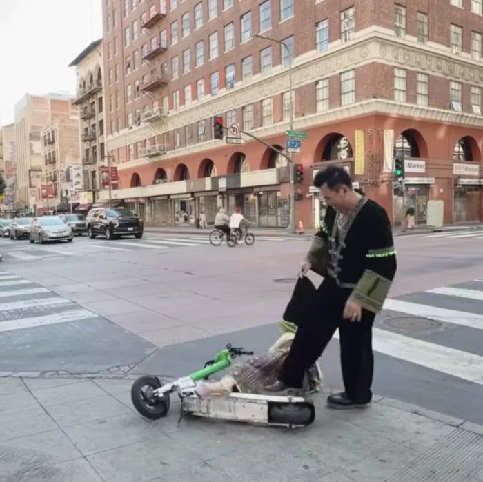 Thúy Nga ngã giữa đường phố Mỹ vì vấp giày cao gót, chiếc xe scooter đổ bên cạnh.