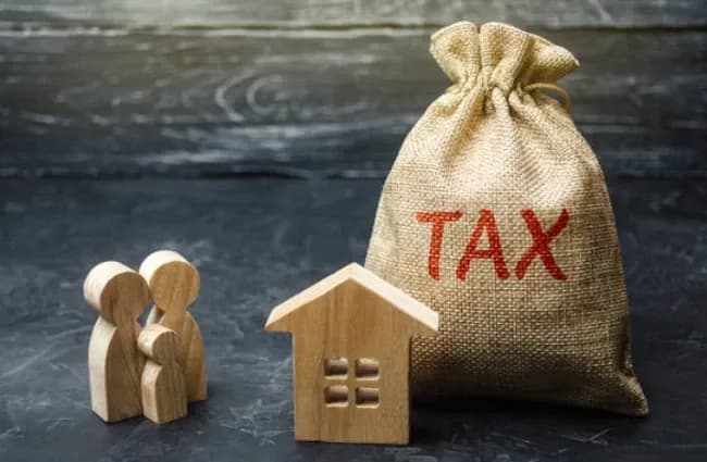 Túi tiền có chữ 'TAX', mô hình nhà và người, tượng trưng cho thuế, gian lận và niềm tin doanh nghiệp.