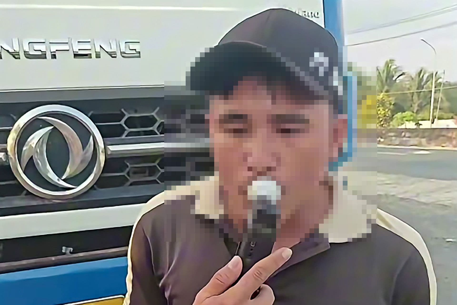 Tài xế xe tải đang thực hiện kiểm tra nồng độ cồn với thiết bị chuyên dụng của cảnh sát giao thông.