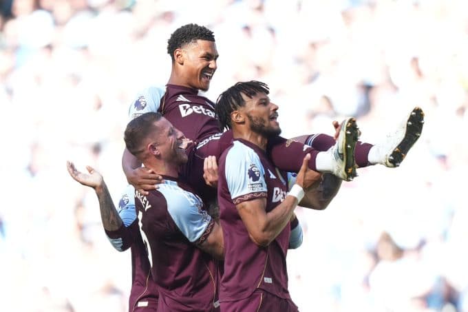 Tiền đạo Ollie Watkins của Aston Villa được đồng đội cõng sau khi ghi bàn vào lưới Man City, một kết quả góp phần vào nghịch lý suất Champions League của Ngoại Hạng Anh.