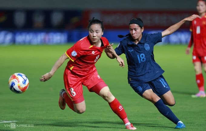 Tiền vệ Trúc Hương của đội tuyển nữ Việt Nam tranh bóng với cầu thủ Campuchia.