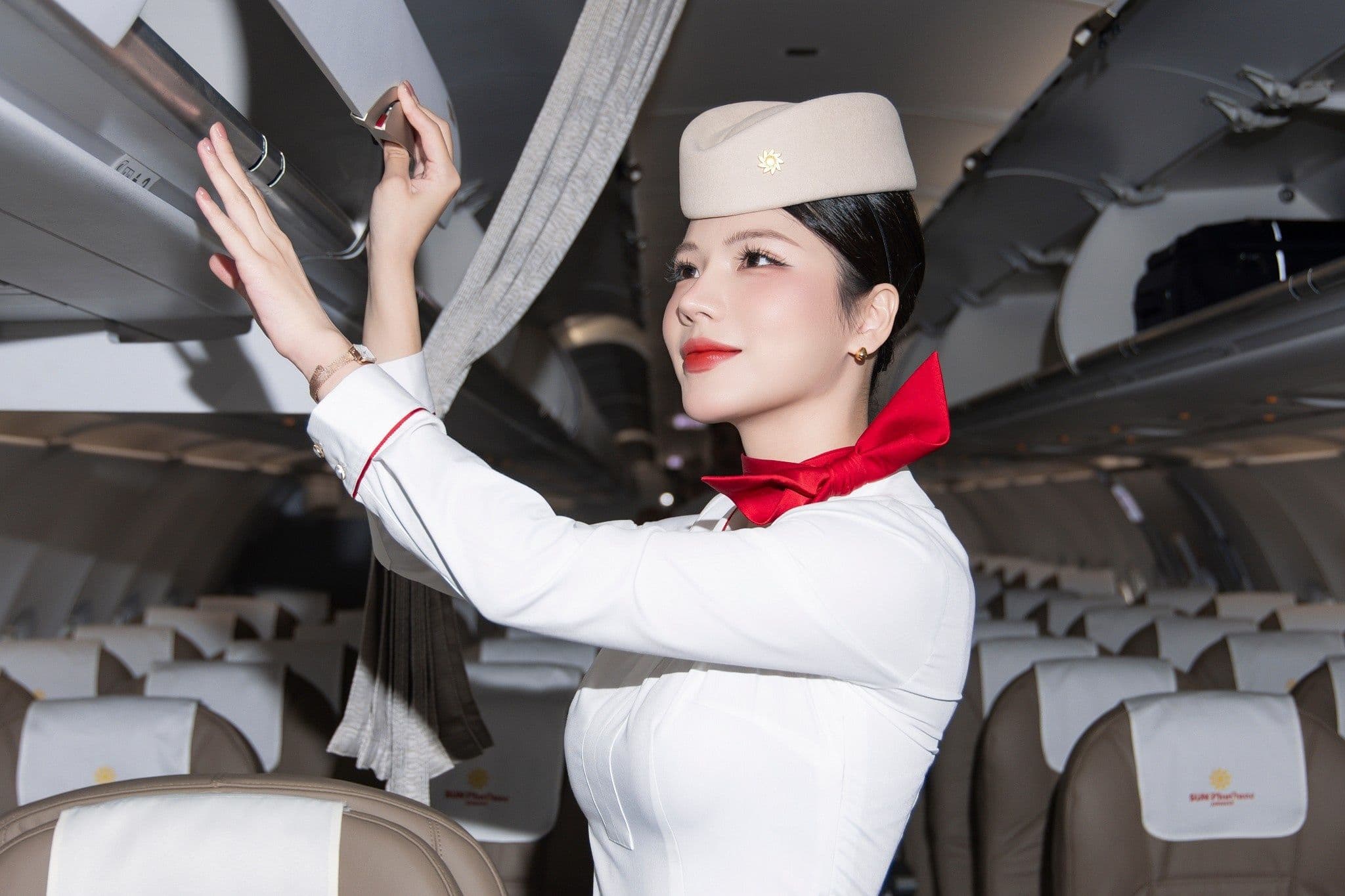 Tiếp viên hàng không Sun Phu Quoc Airways hỗ trợ hành khách với hành lý, thể hiện tinh hoa dịch vụ trên mỗi chuyến bay.