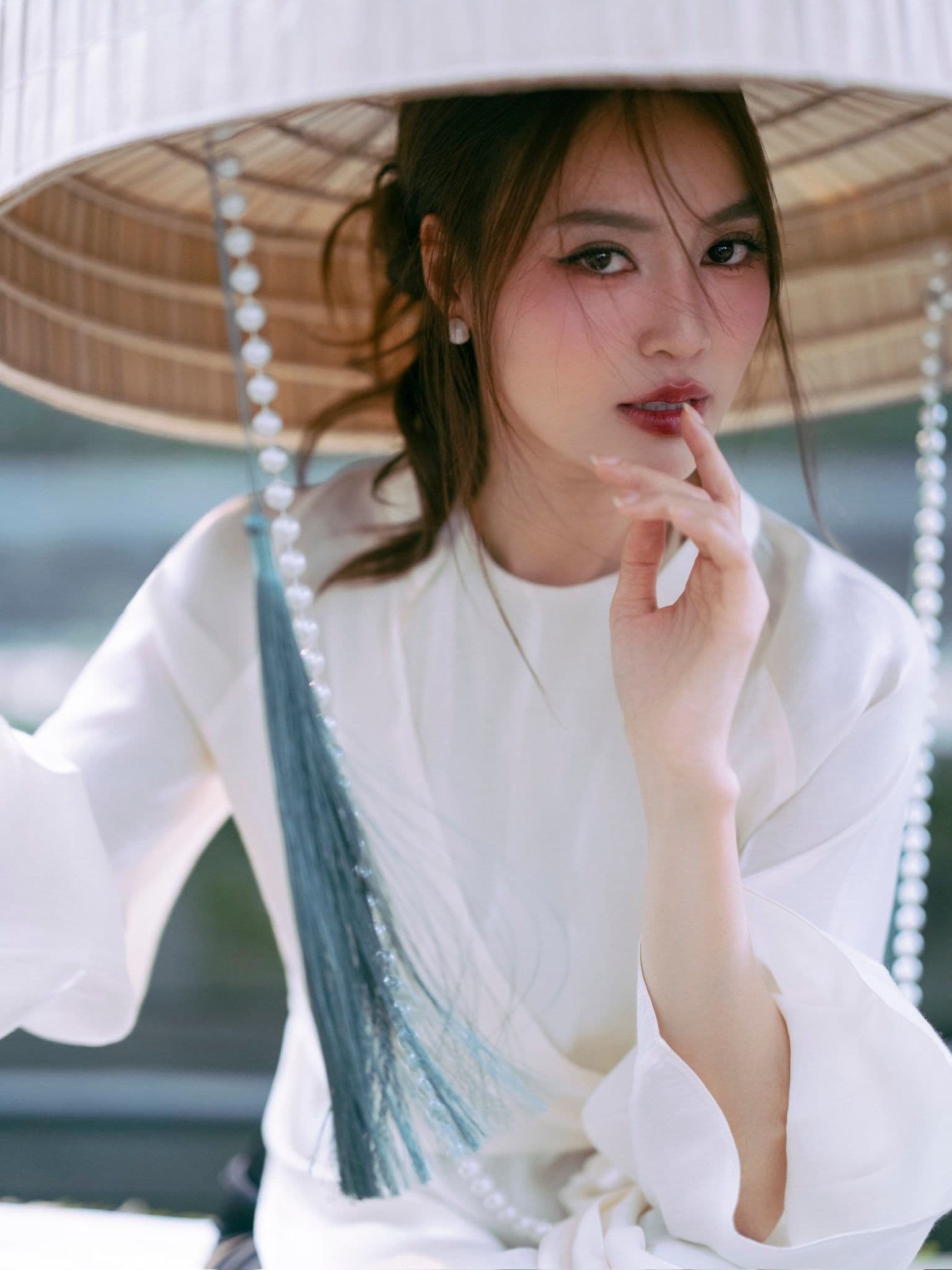 Tăng Thanh Hà thanh lịch trong tà áo dài trắng và nón lá, thể hiện vẻ đẹp vượt thời gian.