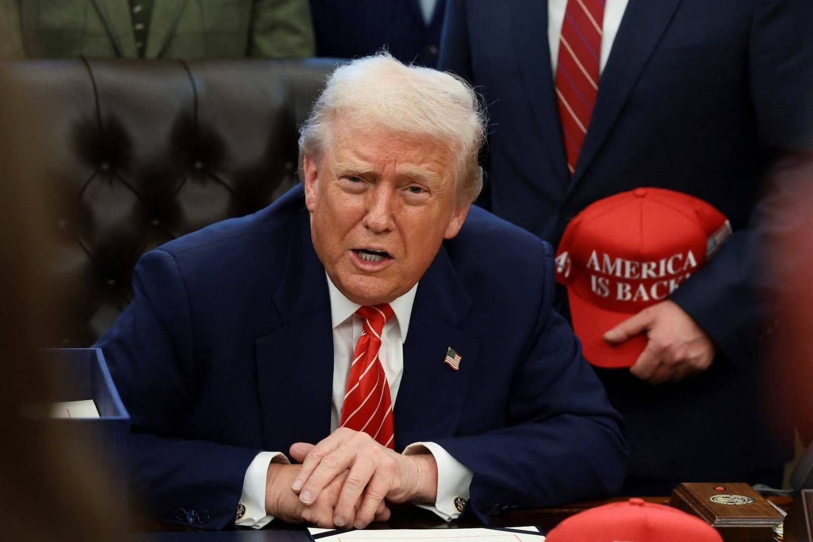 Tổng thống Donald Trump ngồi tại bàn, thể hiện vai trò của Mỹ trong các cuộc đàm phán và tương lai bất định của Trung Đông.