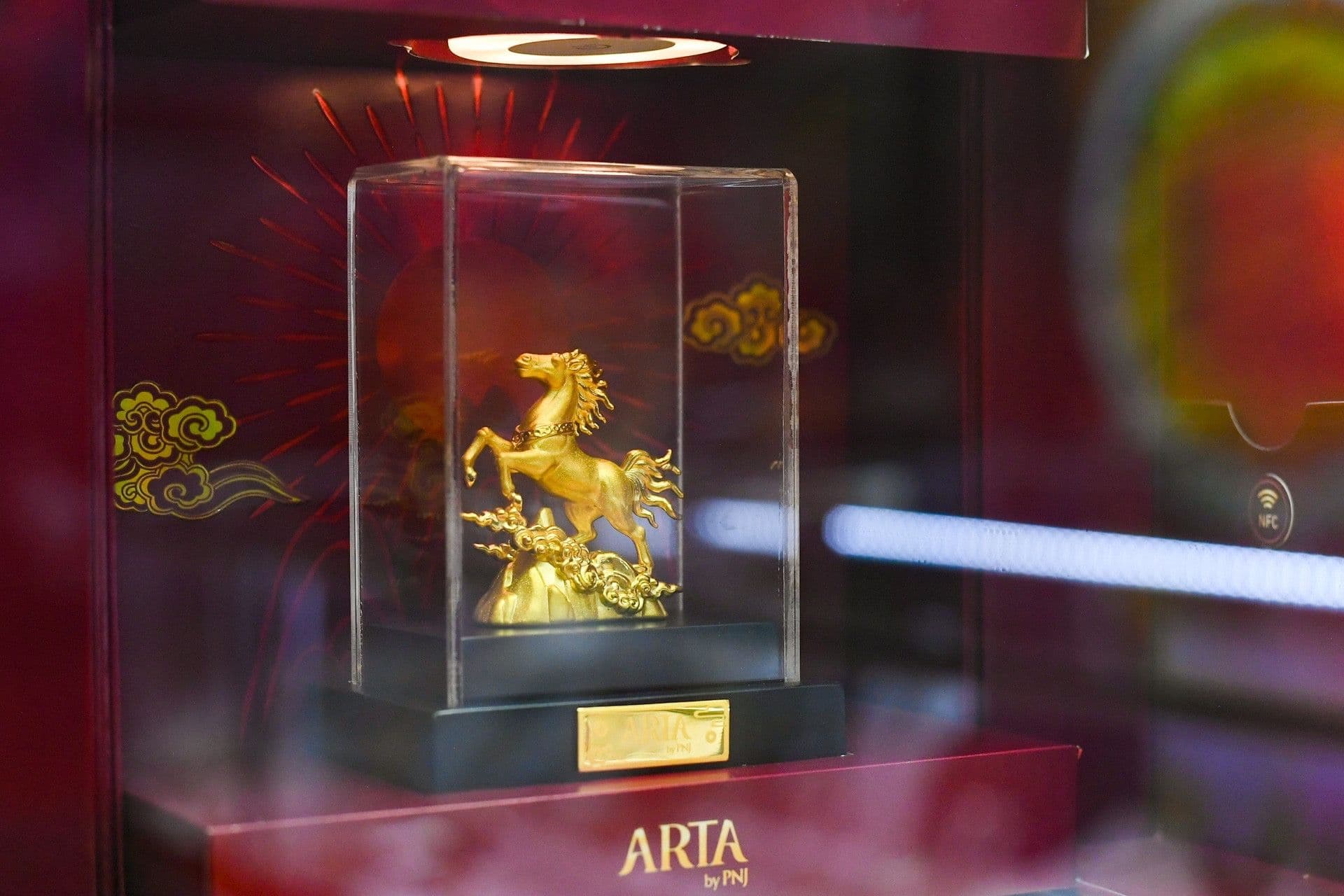 Tượng vàng hình ngựa trong tủ kính, tượng trưng cho giá trị và sự tích trữ tài sản.