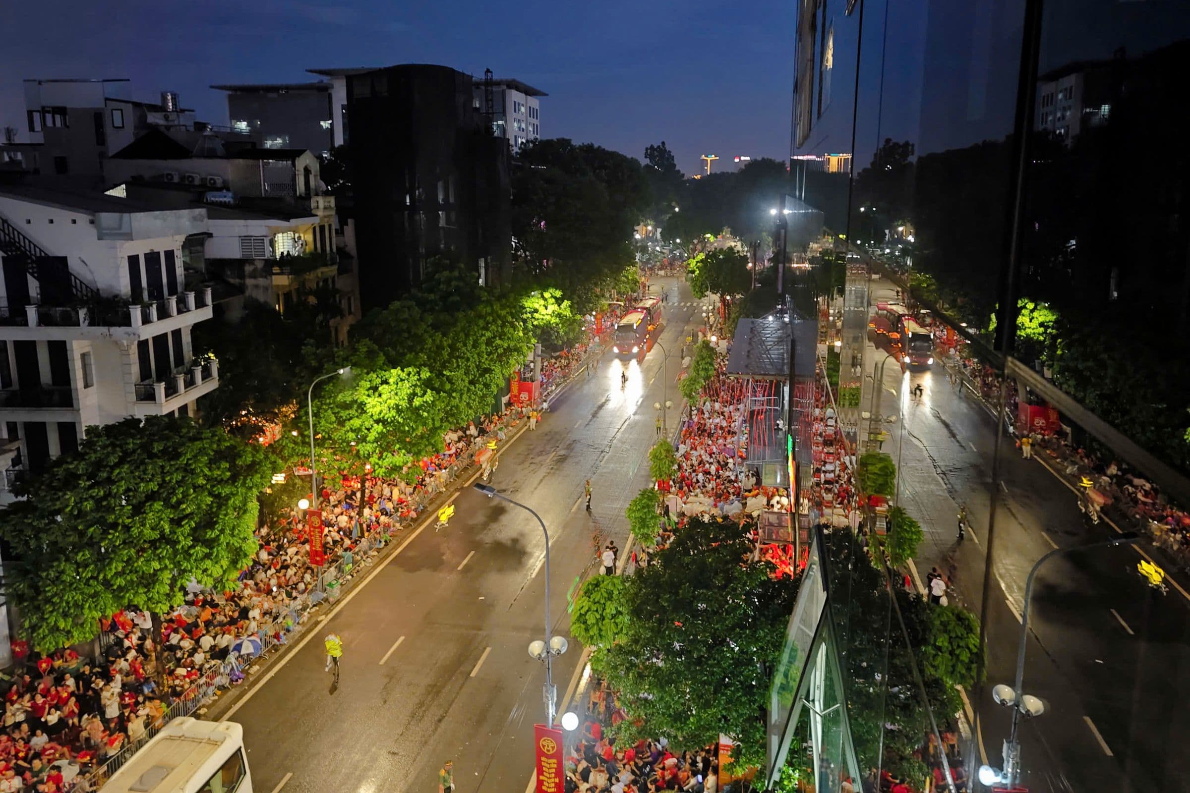 Toàn cảnh đường phố Hà Nội đêm trước Quốc khánh 2/9 với hàng rào an ninh và người dân chờ đợi.