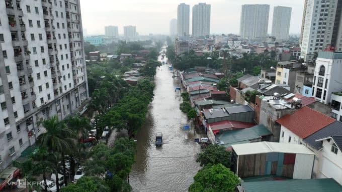 Toàn cảnh đường phố Hà Nội ngập sâu trong nước sau mưa lớn, giữa các tòa nhà cao tầng.