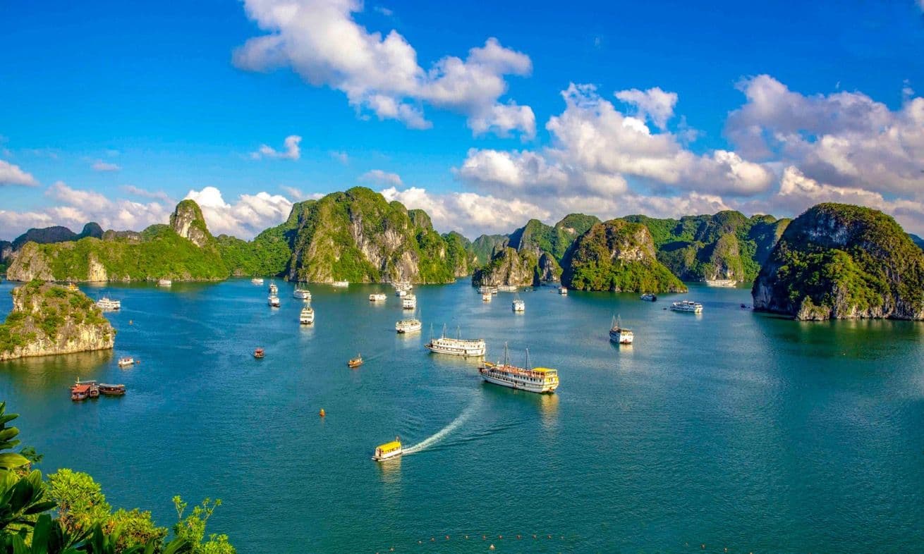 Toàn cảnh Vịnh Hạ Long với các đảo đá vôi xanh biếc và thuyền du lịch trên mặt nước, tượng trưng cho di sản thiên nhiên Quảng Ninh.