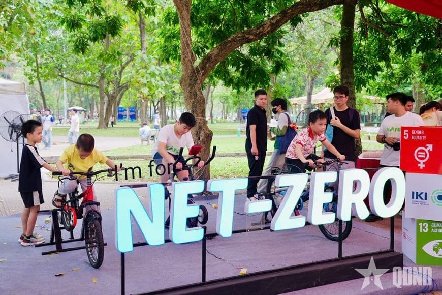 Trẻ em trải nghiệm đạp xe phát điện tại sự kiện Giờ Trái đất, khám phá mô hình ứng dụng năng lượng tái tạo.