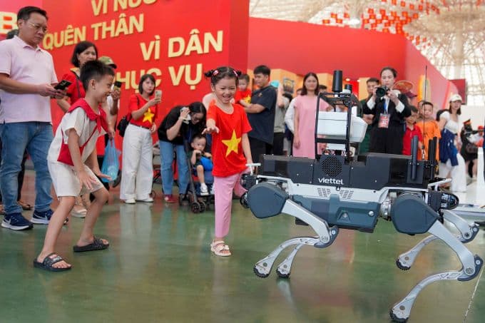 Trẻ em vui vẻ tương tác với robot công nghệ tại Triển lãm A80 Đông Anh, biểu tượng cho tương lai Việt Nam.