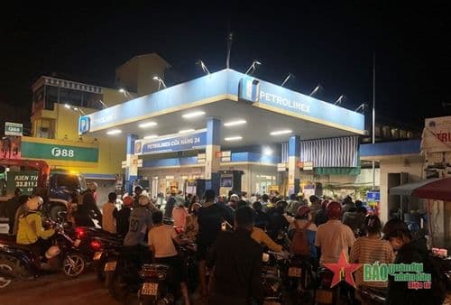 Trạm xăng Petrolimex đông đúc vào ban đêm với nhiều người dân đổ xăng, phản ánh tâm lý lo ngại và tích trữ nhiên liệu khi giá tăng.