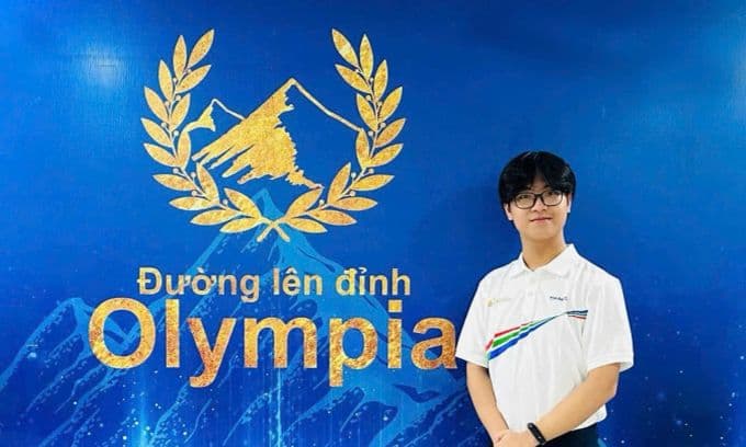 Trần Bùi Bảo Khánh, thí sinh chung kết Đường lên đỉnh Olympia 25, đứng trước logo chương trình.