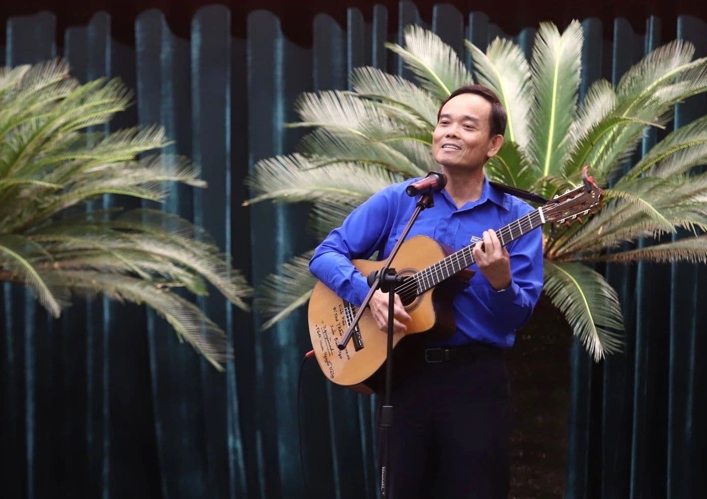 Trần Lưu Quang ôm đàn guitar và hát, tạo không khí thân tình trong buổi đối thoại với thanh niên.