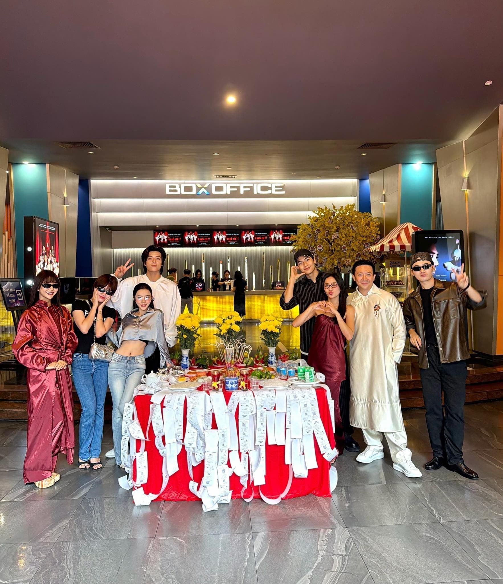 Trấn Thành và dàn diễn viên phim 'Thỏ ơi' chụp ảnh trước quầy vé rạp chiếu phim, với nhiều vé đã bán trên bàn