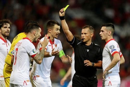 Trọng tài rút thẻ vàng cho cầu thủ trong trận đấu bóng đá.