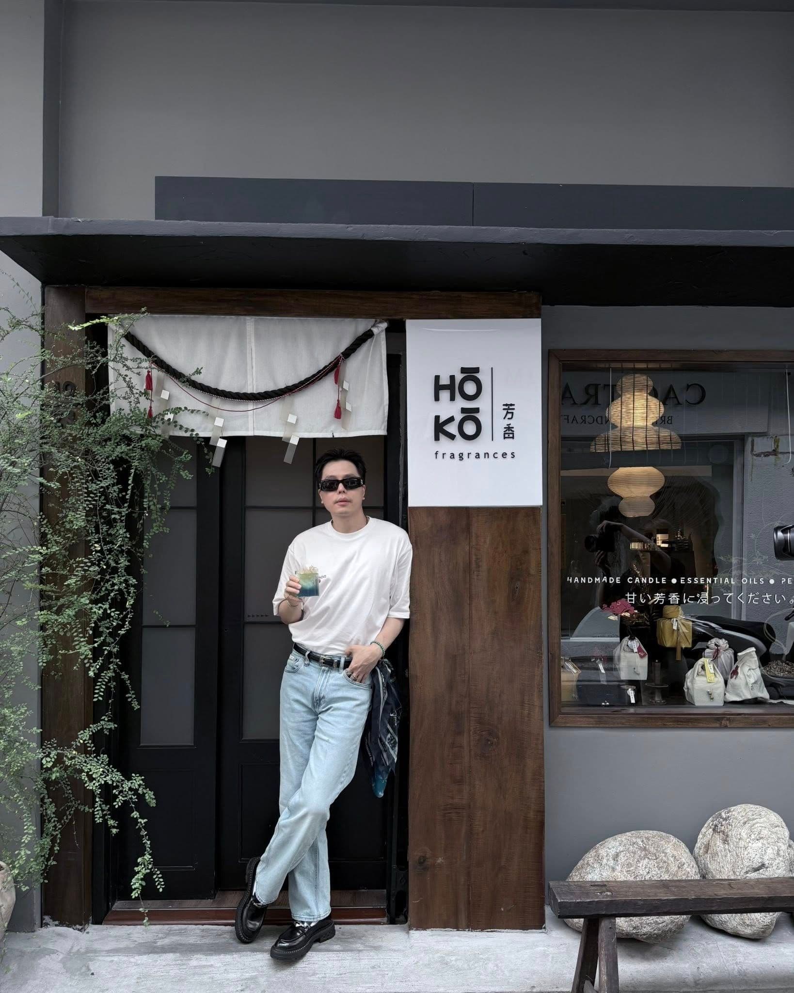 Trịnh Thăng Bình đứng trước cửa hàng, phong cách thời trang lịch lãm, thể hiện sự chuyển mình sang lĩnh vực kinh doanh.