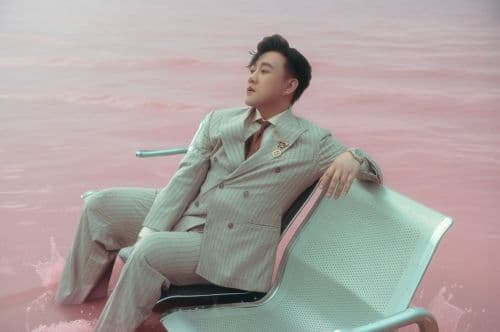 Trung Quân Idol ngồi giữa làn nước màu hồng, tượng trưng cho những cảm xúc sâu lắng và biệt danh 'Thánh Mưa'