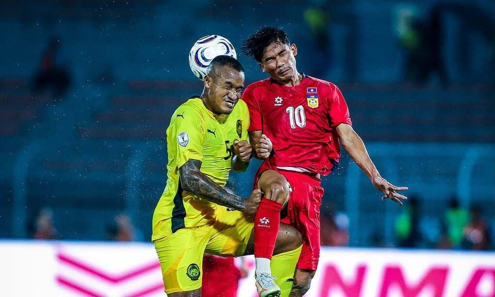 Trung vệ Malaysia Rodney Celvin Akwensivie tranh bóng trên không với tiền đạo Lào Soukphachan Lueanthala trong trận đấu ASEAN Cup 2026.