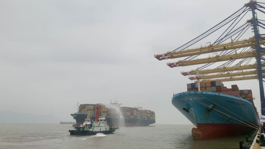 Tàu container lớn đang bốc dỡ hàng tại cảng biển, minh họa hoạt động kinh tế sôi động.