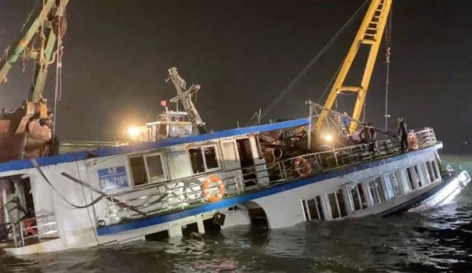 Tàu du lịch Vịnh Xanh 58 bị lật đang được kéo vào bờ tại Vịnh Hạ Long, thể hiện nỗ lực khắc phục sự cố và cam kết an toàn biển.