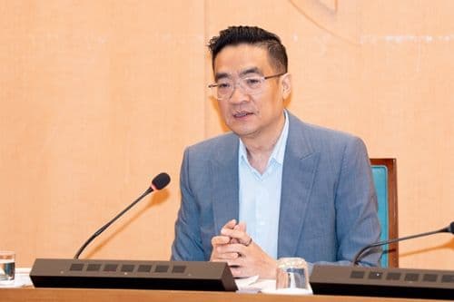 Tàu điện chạy qua khu dân cư đông đúc, thể hiện sự chuyển dịch sang phương tiện giao thông công cộng khi giá xăng tăng.