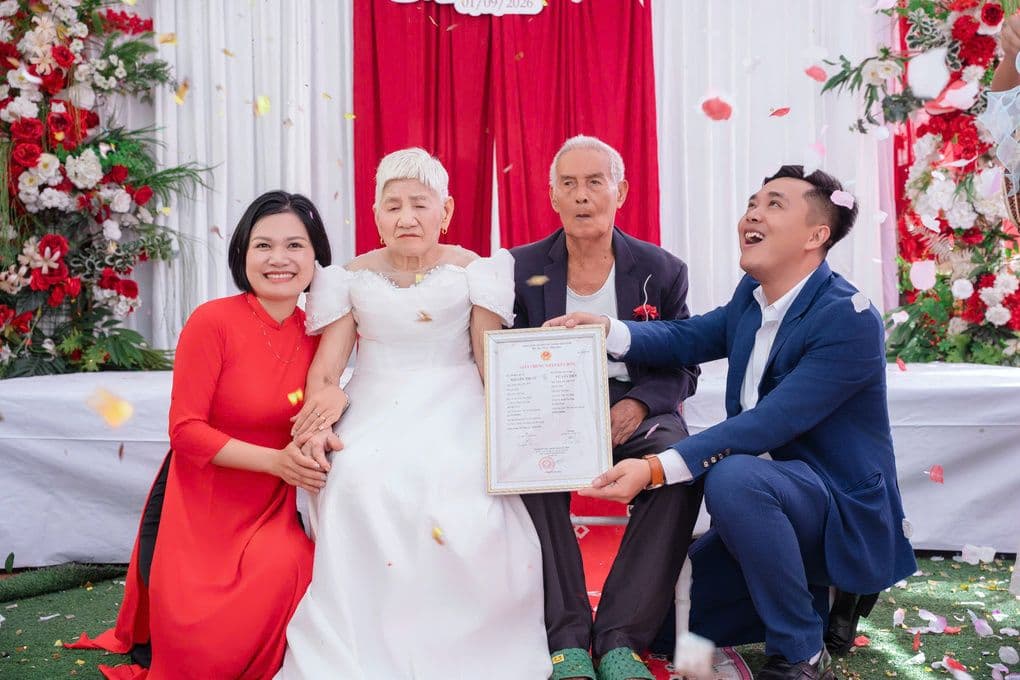 Vợ chồng anh Đức Linh và chị Hương Trà trao giấy đăng ký kết hôn tượng trưng cho ông bà nội 93 tuổi trong hôn lễ tái hiện.