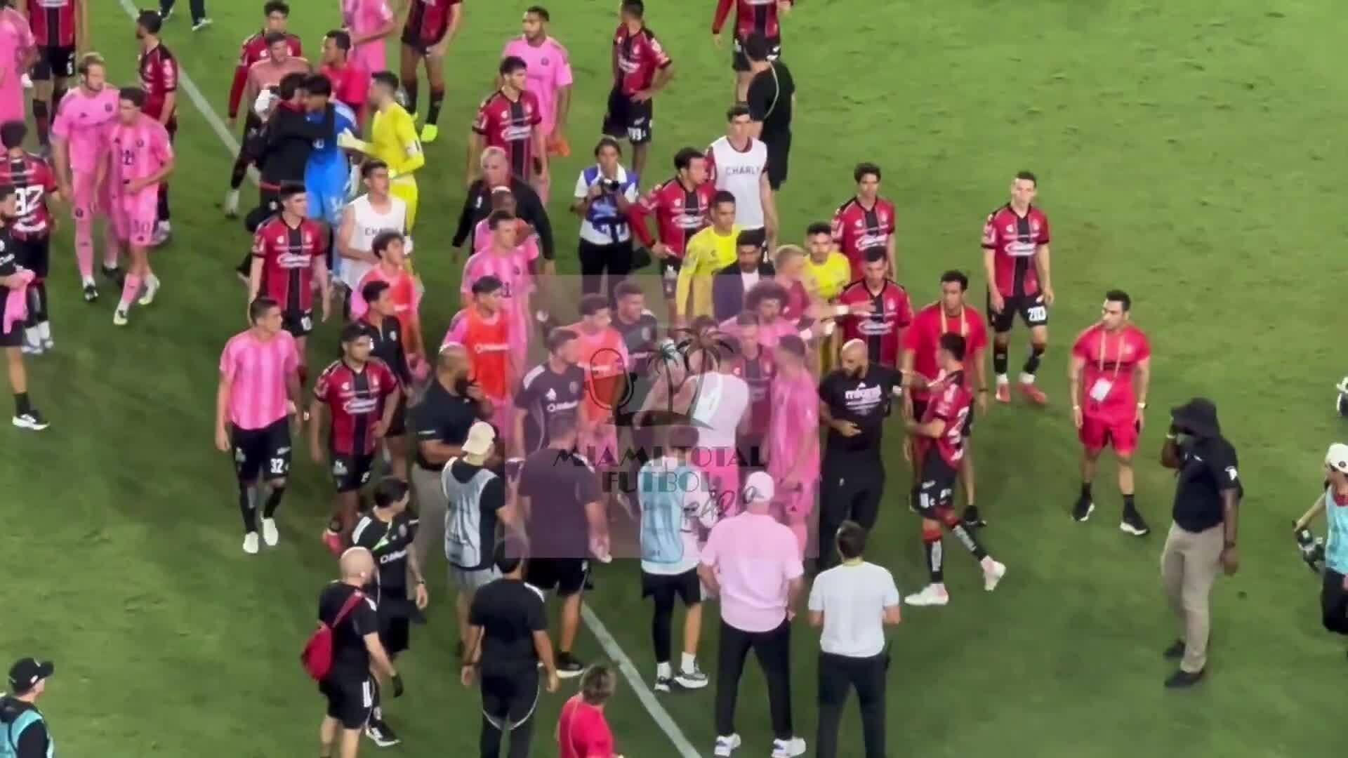 Vệ sĩ của Messi (áo đen) giữa các cầu thủ trên sân, minh họa sự can thiệp vào trật tự trận đấu và ranh giới quyền hạn.