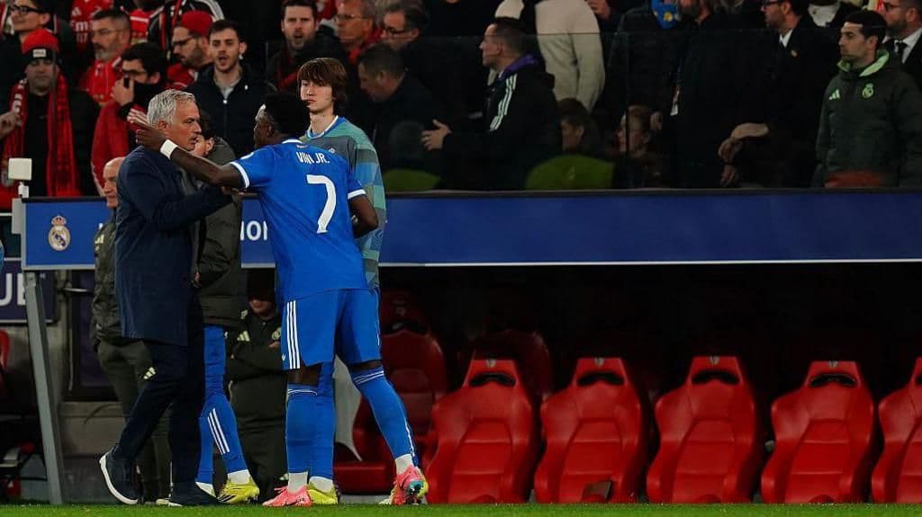 Vinicius Junior của Real Madrid nói chuyện với huấn luyện viên Jose Mourinho của Benfica bên lề sân, trong bối cảnh những phản ứng đa chiều từ dư luận.