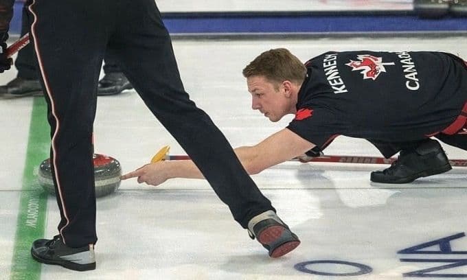 Vận động viên Marc Kennedy của Canada chạm tay vào bi đá trên băng, gây tranh cãi về gian lận tại Olympic Mùa Đông 2026.