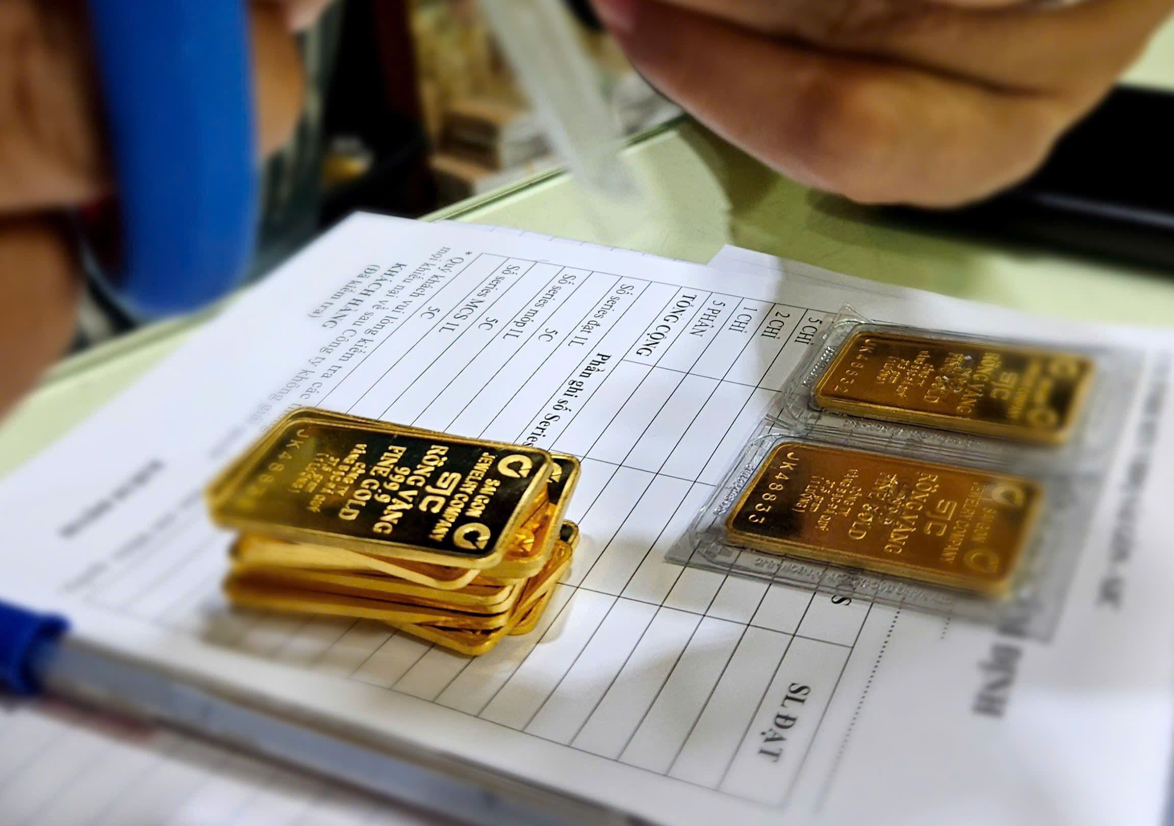 Vàng miếng SJC và vàng nhẫn trên giấy tờ giao dịch, thể hiện sự 'hạ nhiệt' và chuyển mình của thị trường vàng nội địa.
