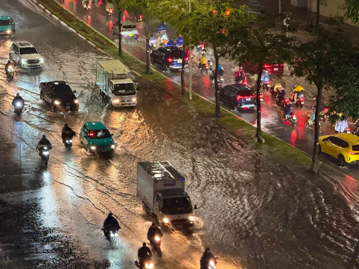 Xe cộ di chuyển trên đường phố ướt át sau cơn mưa lớn, thể hiện sự thay đổi đột ngột của thời tiết.