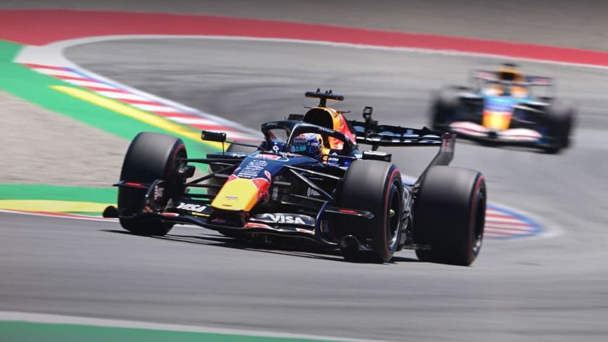Xe F1 trên đường đua Barcelona, tượng trưng cho sự thay đổi không ngừng và cần tái sinh liên tục.
